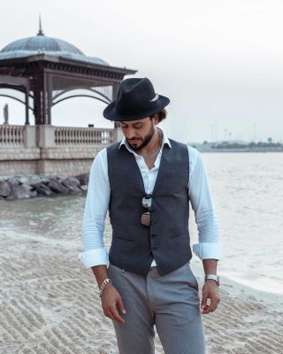 Professional Abu Dhabi photographer capturing Arab man in hat on a beach photoshoot.