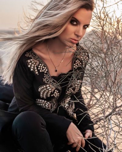 Close up of a beautiful Russian lady dressed in Arabic stylised dress posing in Dubai desert.