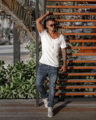 Professional Dubai photographer capturing handsome man in white shirt and jeans.