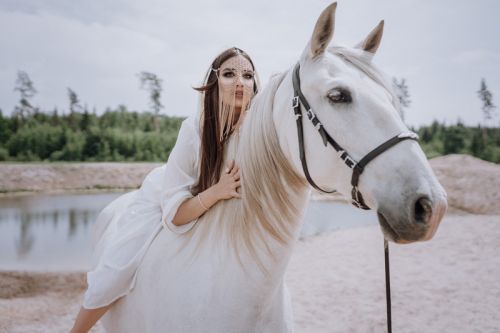 Woman with a horse in the Dubai desert during an elegant outdoor photoshoot.